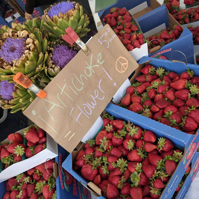 Market crates of strawberries and artichokes